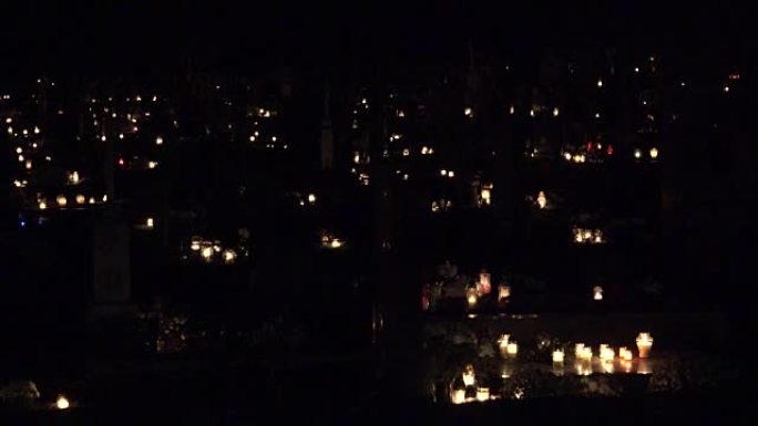 聚焦在墓地黑暗中点亮的许多蜡烛上。FullHD