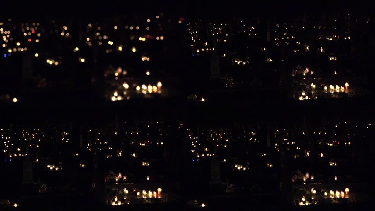 聚焦在墓地黑暗中点亮的许多蜡烛上。FullHD