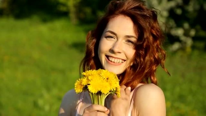 美丽的年轻女孩带着一束鲜花微笑