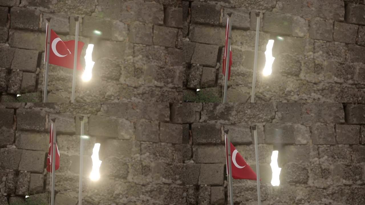 日落时在石墙背景上的土耳其国旗