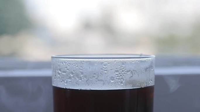 红茶在窗台上从老式玻璃中蒸出来的特写镜头。