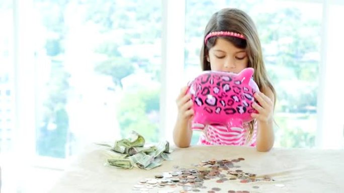 小女孩清空她的粉红色存钱罐