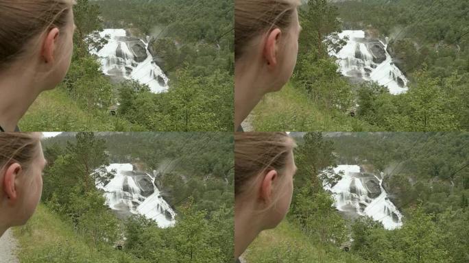 女孩看着山上的瀑布