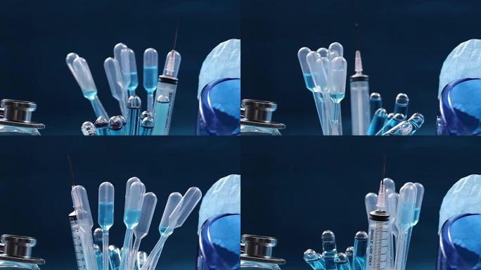 玻璃管测试实验室中的蓝色液体，滴管，注射器，模糊头盔，听诊器和护目镜，在设备上旋转的管