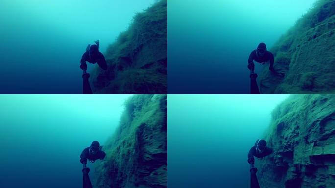 自由潜水员探索水下悬崖的一侧进入采石场