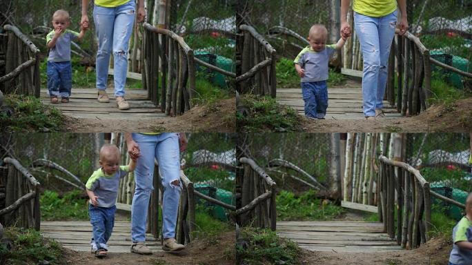 漂亮的年轻母亲带着可爱的小儿子过桥