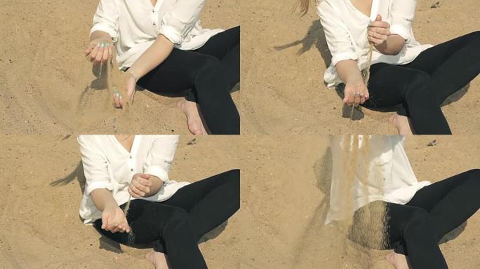 女孩坐在沙滩上，将沙子倒入
