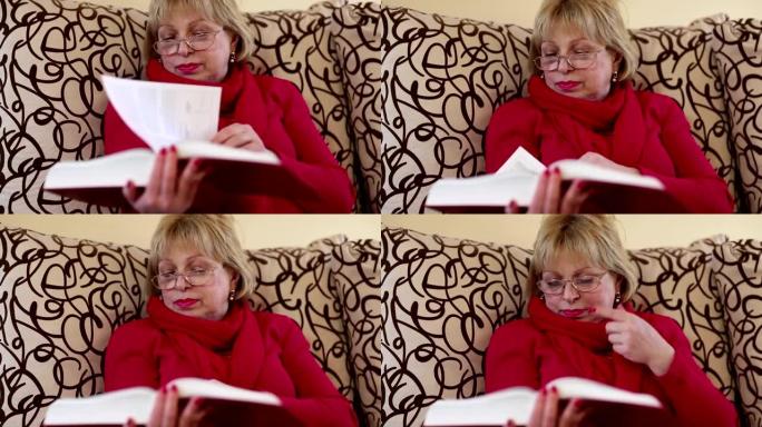 女人坐在沙发上翻阅一本大书的书页