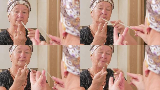 年纪大的女人在浴缸里自己修指甲。它使用指甲锉。可以看到它在镜盒中反射。美容概念