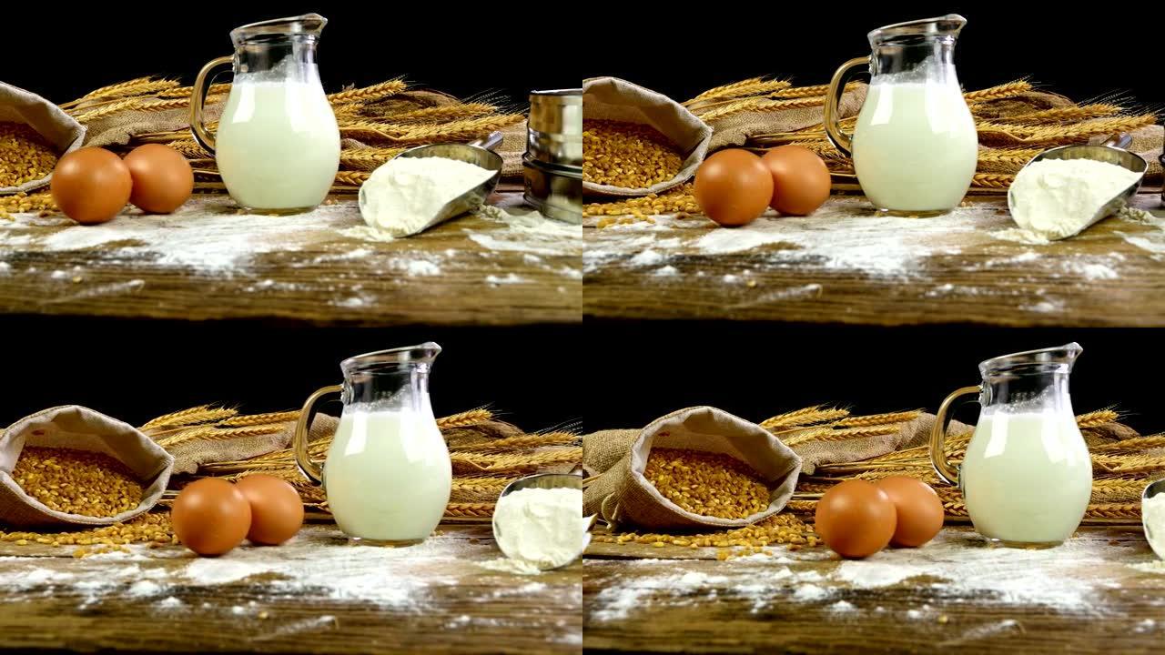 小麦子，面粉，面包，牛奶，鸡蛋和黄油放在木桌上，多莉