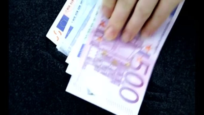 女商人拿了一大笔欧元，在一笔好交易成功的钱从口袋里掏出来之后，她就把钱放进了口袋里