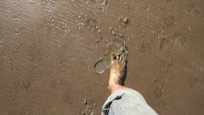 一个人的腿穿过泥泞