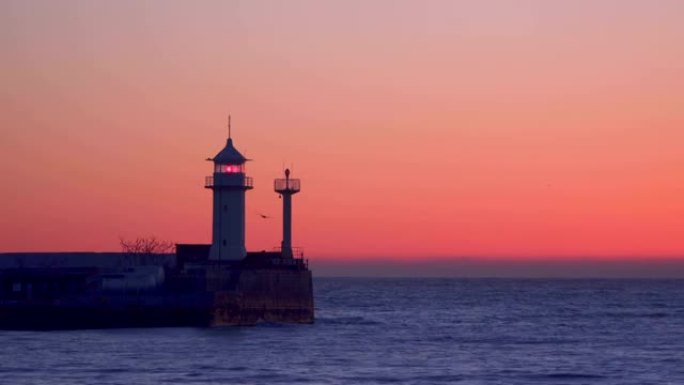 黎明时灯塔闪烁的码头。雅尔塔克里米亚