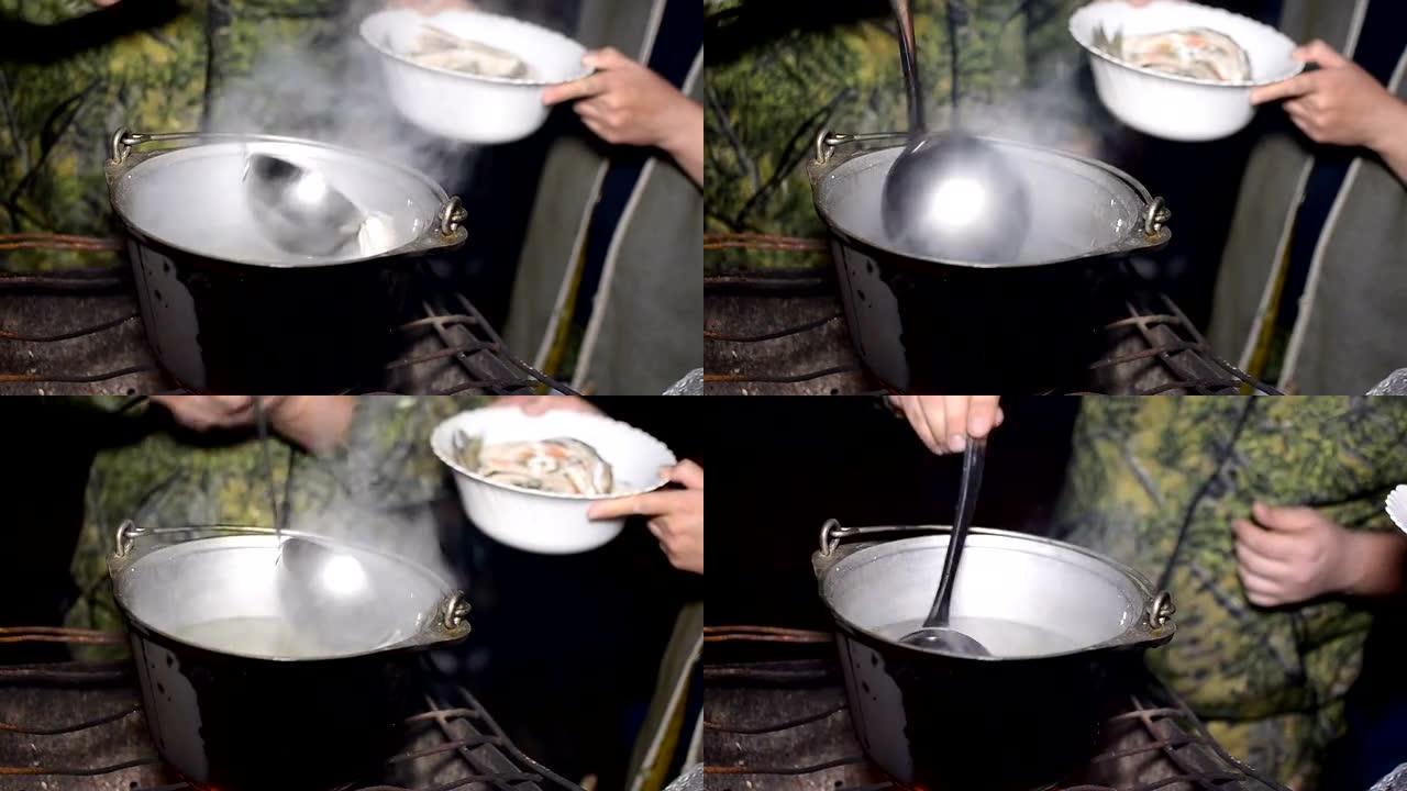 人类将钢包放入一碗炸鱼锅中，汤是在自然界的火上煮熟的