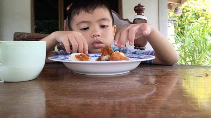 男孩吃炸鸡和蒸糯米饭