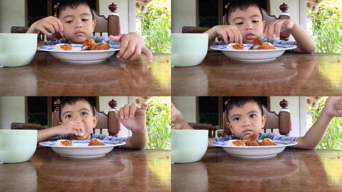 男孩吃炸鸡和蒸糯米饭