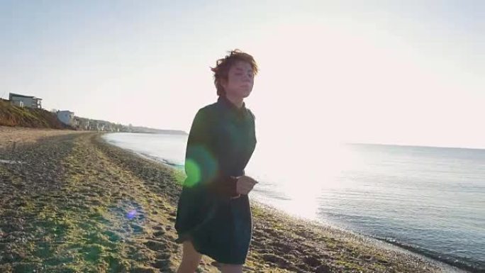 日落或日出时，年轻的高加索红发女孩在海滩上跑步