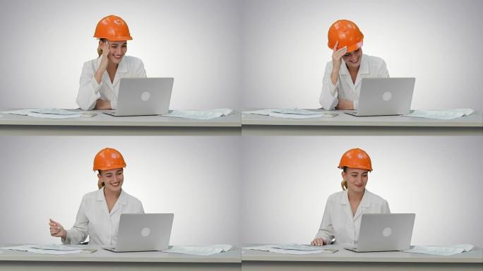 安全帽的女性建筑专家与白色背景上的朋友在线视频聊天