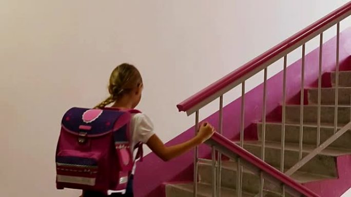女学生上楼楼梯学校回家。回到学校。回家吧。上教室。背包粉色背女孩白色高加索漂亮女孩。一步一步走。蓝色
