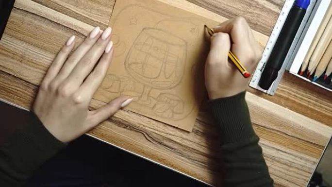 生活方式: 年轻美丽的女孩的手自由艺术家设计师在克拉夫纸上素描和绘制食物插图，在家工作。自上而下拍摄