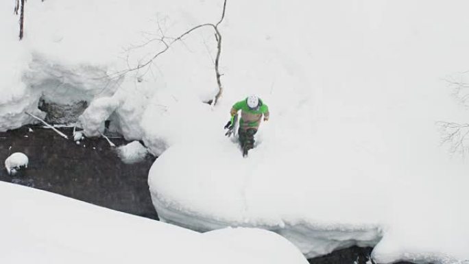 滑雪者危险地在日本深雪雪中跳过河