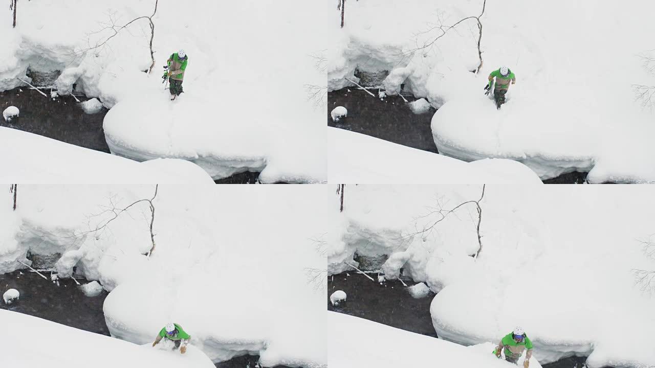 滑雪者危险地在日本深雪雪中跳过河