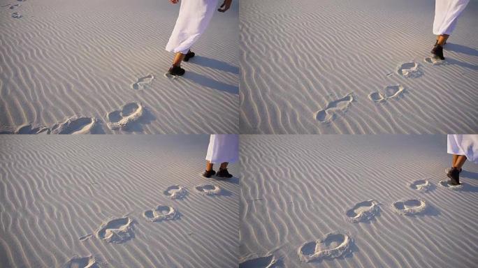 在温暖的夏夜，拍摄阿拉伯酋长穿着民族服装在沙丘上行走的特写镜头