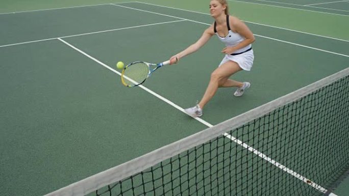 一名女网球运动员在网上凌空抽射，庆祝成为第一名。