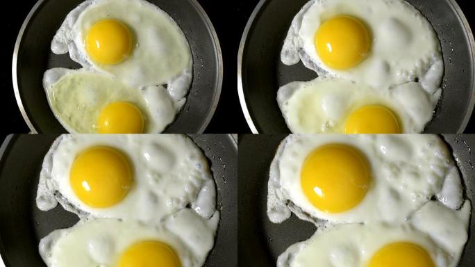 两个鸡蛋在平底锅里煎。时间流逝。放大。摄像机的旋转。