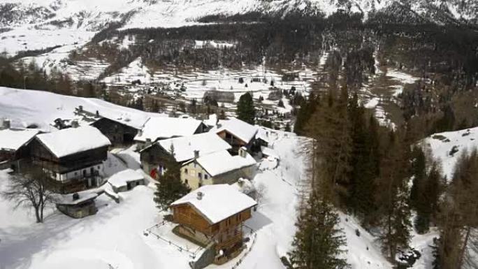 冬季空中无人驾驶飞机在冰山下的白雪皑皑的小镇和森林森林山谷上建立。户外山地自然中的雪。下飞机。探索阿