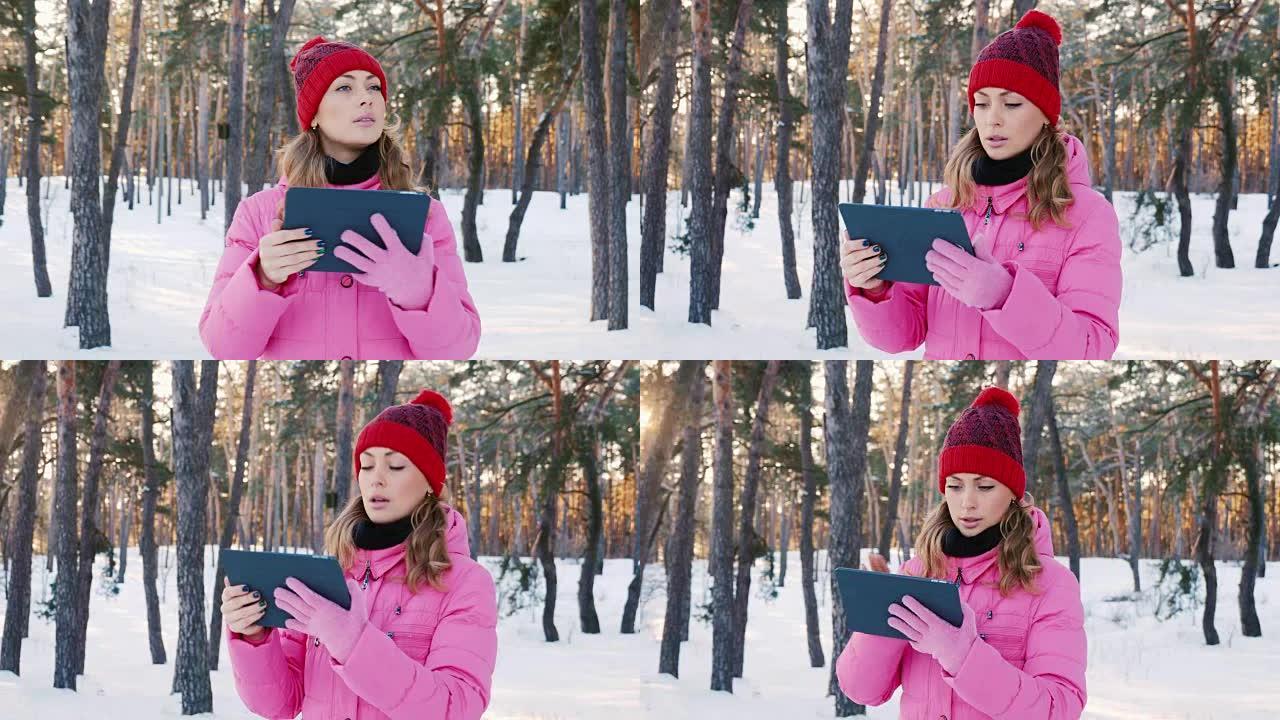 年轻女子寻找正确的方式，使用平板电脑或GPS导航仪。M在白雪皑皑的冬季森林中