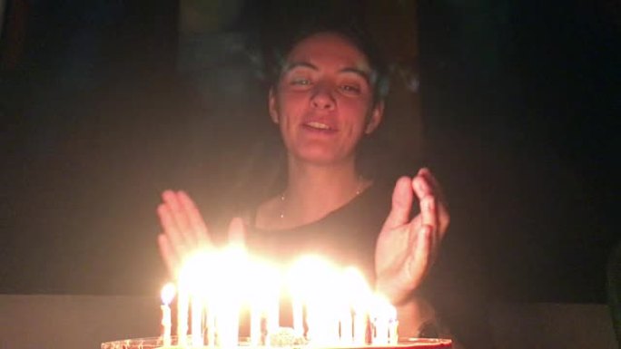 女人在生日蛋糕前微笑。庆祝生日的女人