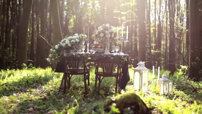森林里大自然的婚礼装饰。巧克力色调的婚礼装饰。婚礼桌上的巧克力蛋糕，森林里有鲜花。