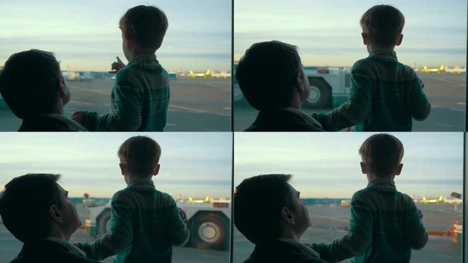 儿子和爸爸透过窗户看着机场区域