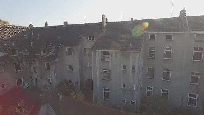 在德国煤炭开采小镇格拉德贝克 (Gladbeck) 的一个废弃地区的空中，在一排破旧的房屋前从右向左