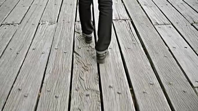 年轻女子独自走在河上的木墩或桥上，观点透视