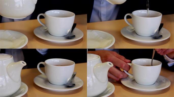 男性双手合拢将茶倒入杯子和汤匙