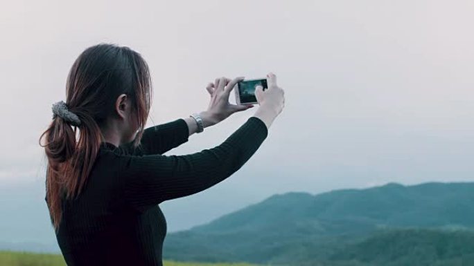 美丽的女人在泰国北部的稻田用智能手机拍照