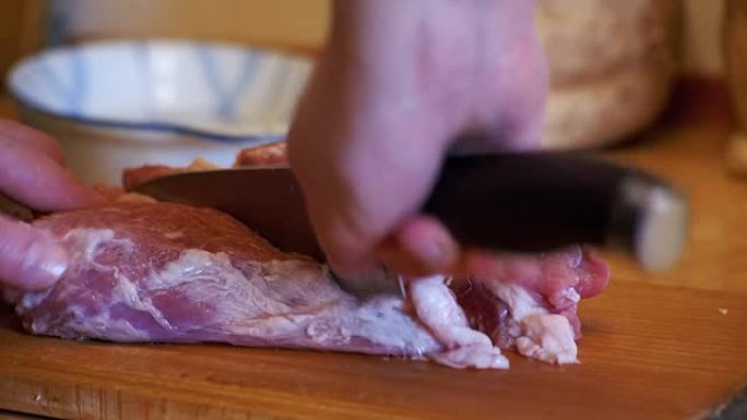 女厨师将切成薄片的肉扔在家庭厨房的砧板上