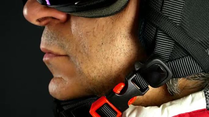 滑雪者/滑雪者将头盔扣在黑色背景上，特写
