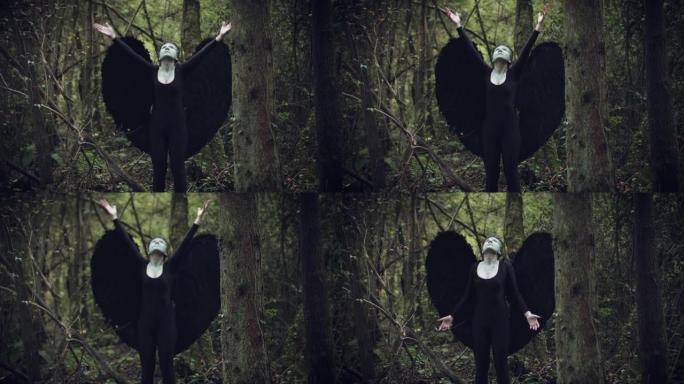4k万圣节黑天使女人，黑色翅膀在森林里举起手来