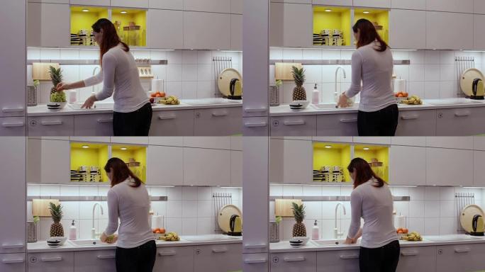 一个女人在厨房的水槽里洗葡萄