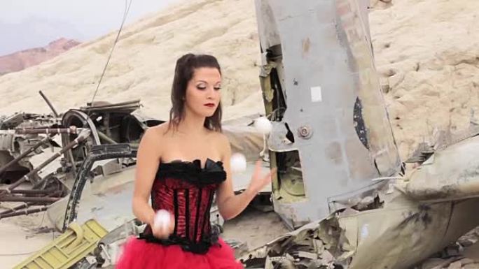 这个女孩在被摧毁的飞机的背景上玩杂耍