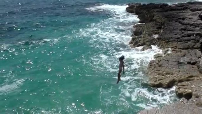 高清超级慢动作-女孩从岩石跳到海里。