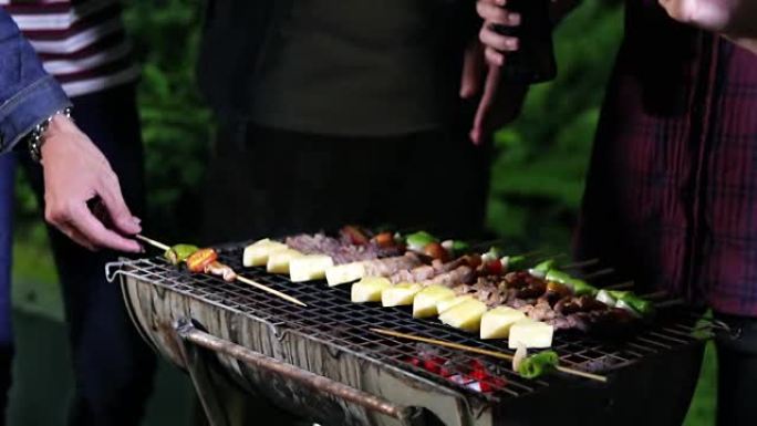亚洲一群朋友在户外花园的炉排派对上做烧烤和烤肉串