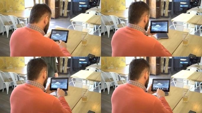 男子在平板电脑上使用应用程序检查互联网上的天气，靠近镜头