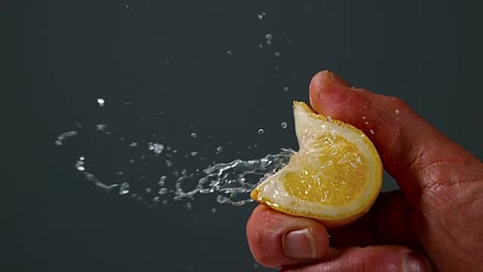 男人挤柠檬的手，黑色背景下的柑橘柠檬酒，慢动作4K