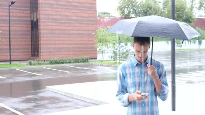 使用智能手机，下雨时站在伞下