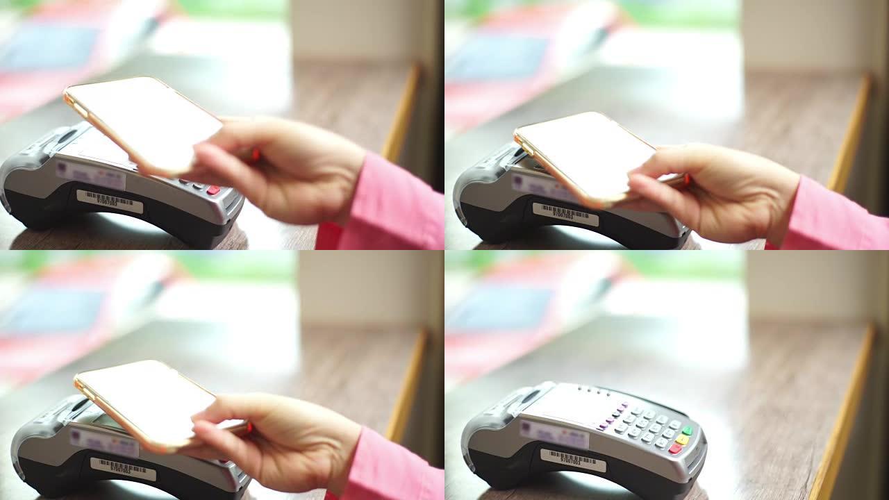 女人在咖啡馆的智能手机上使用NFC技术支付无线费用。