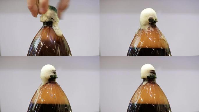 Man fail打开一个装有苏打水的塑料瓶的盖子。克瓦斯，黑啤酒泡沫